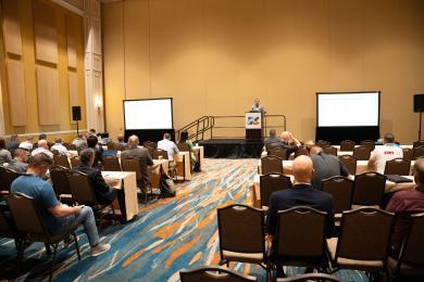 Small conference room with people listening to speaker
